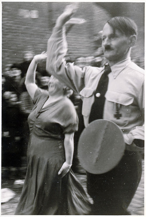 Eine Frau ahmt den Hitler-Darsteller nach
